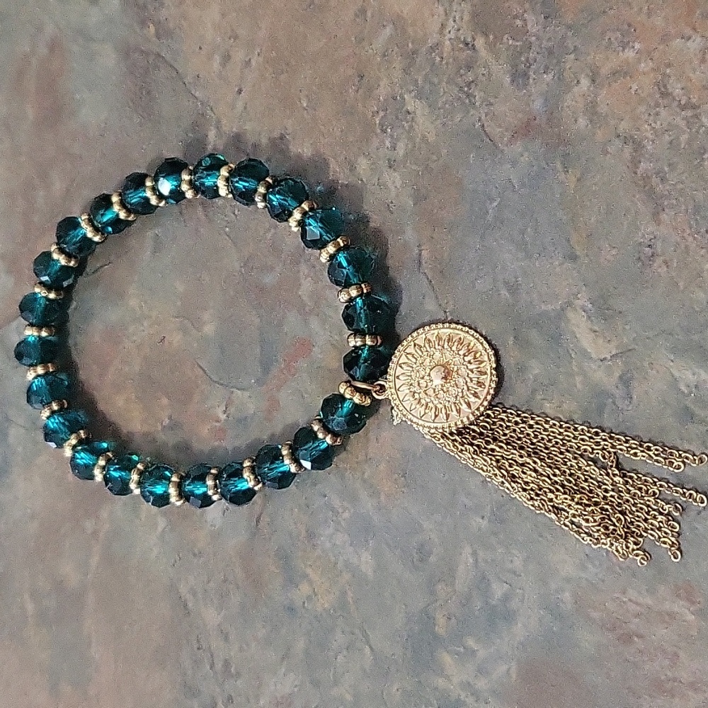 Beautiful teal colored beaded bracelet with gold tone tassel